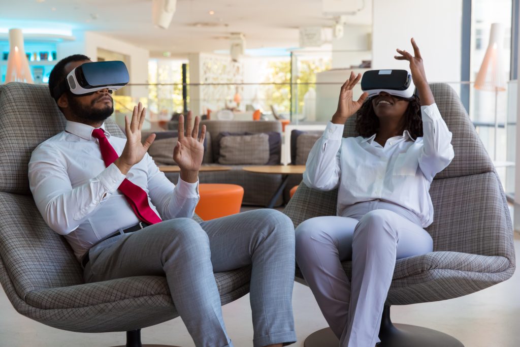 Excited diverse colleagues in VR glasses playing virtual game